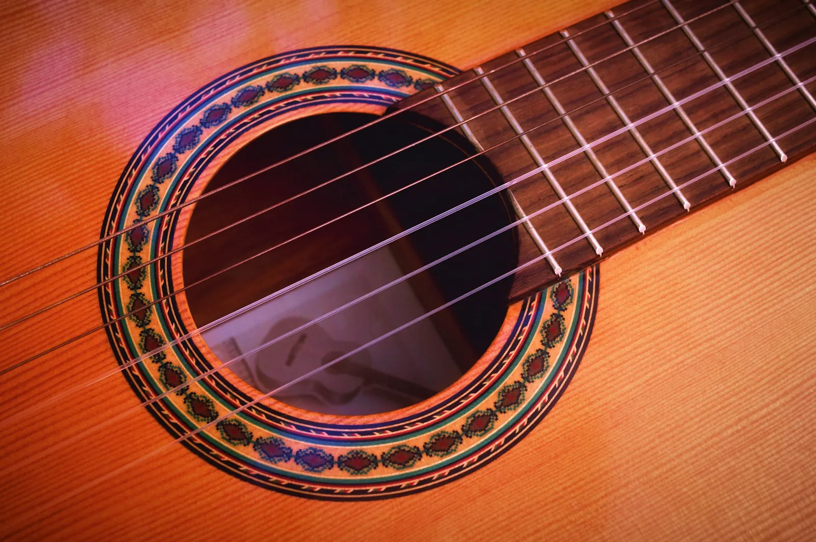 The soundhole and mosaic rosette of a classical guitar
