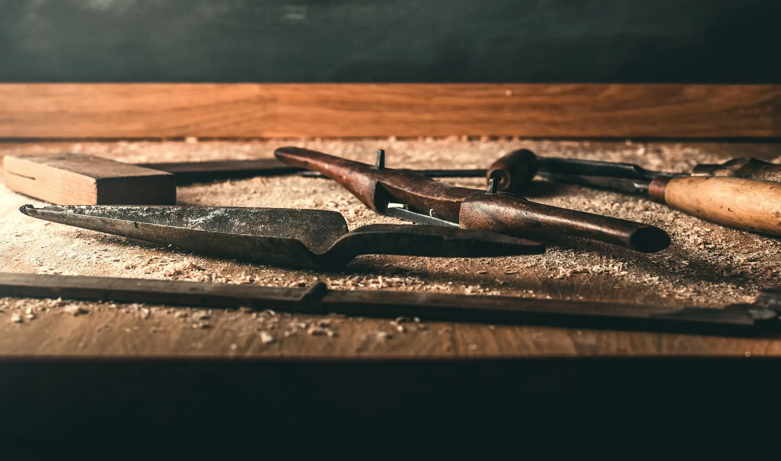 Carving gouges lying in wood shavings on a bench