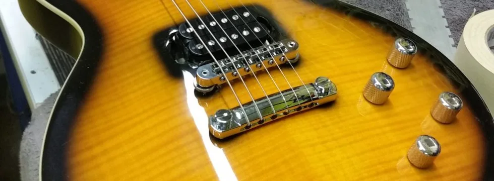 Close-up of a tobacco sunburst flame maple top with its bridge and tailpiece