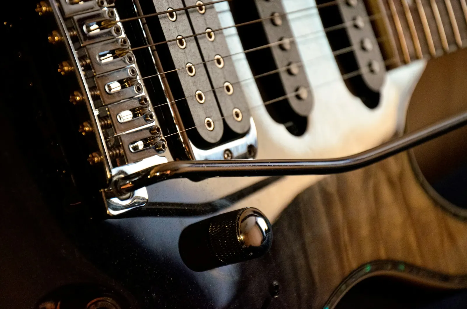 The bridge saddles and single-coil pickups of a Stratocaster-style guitar
