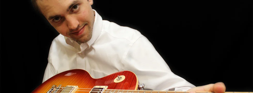Wesley Wilkerson with a red Les Paul–style guitar